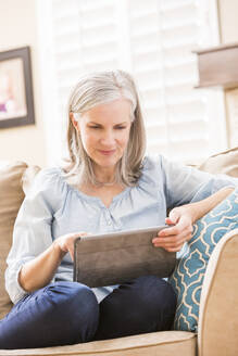 Kaukasische Frau mit digitalem Tablet auf dem Sofa - BLEF09724