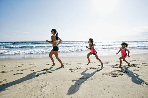 Mutter und Töchter laufen am Strand - BLEF09737