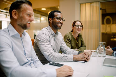 Lächelnde Vertriebsmitarbeiter bei einem Geschäftstreffen am Konferenztisch im Büro - MASF13016