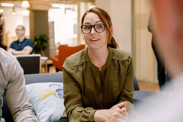 Selbstbewusste Geschäftsfrau mit Brille, die im Büro sitzt - MASF13031