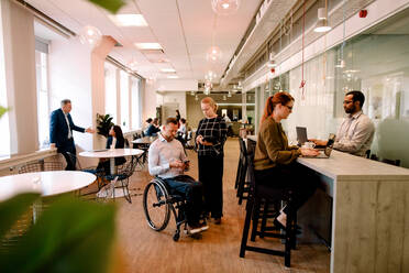 Business colleagues talking and working in office cafeteria - MASF13045