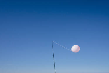 Luftballon an Mast in blauem Himmel gebunden - BLEF09741