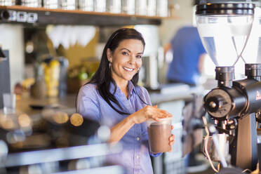 Hispanischer Barista macht Kaffee in einem Cafe - BLEF09742