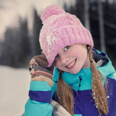 Kaukasisches Teenager-Mädchen mit Beanie-Mütze im Schnee, lizenzfreies Stockfoto