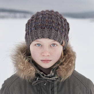 Kaukasisches Teenager-Mädchen mit Beanie-Mütze im Schnee - BLEF09753