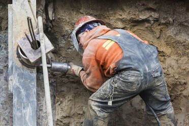 Caucasian worker drilling at construction site - BLEF09820