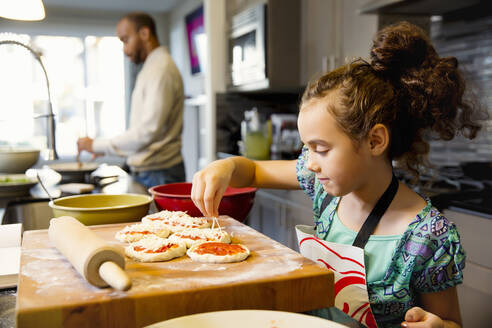 Gemischtrassiges Mädchen beim Kochen in der Küche - BLEF09834