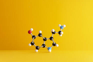 Caffeine formula's molecular structure over yellow background - DRBF00155