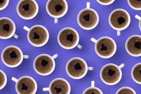 Directly above view of fresh coffee in cups over purple background - DRBF00158