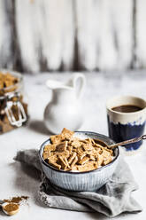 Close-up of fresh homemade baked cinnamon cereals with yogurt in bowl on table - SBDF03996