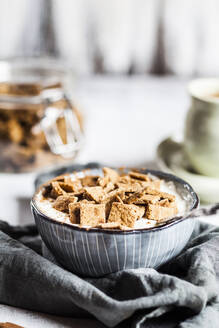 Nahaufnahme von frischen hausgemachten gebackenen Zimt Müsli mit Joghurt in der Schüssel auf Serviette - SBDF03997