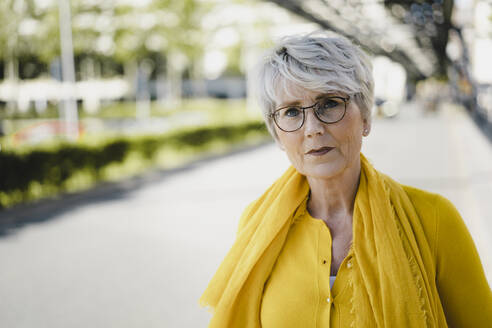 Porträt einer reifen Frau mit grauem Haar, Brille und gelber Kleidung - KNSF06093