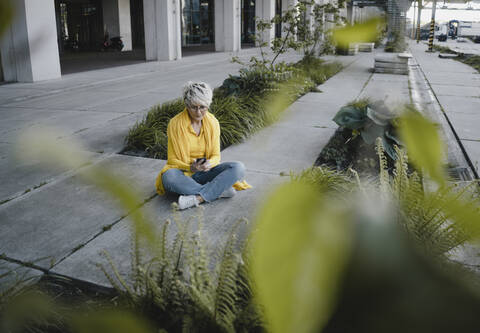 Mature woman using smartphone outdoors stock photo