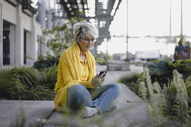 Ältere Frau benutzt Smartphone im Freien - KNSF06118
