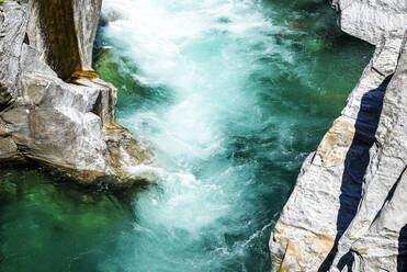 High angle view of Verzasca river flowing amidst rock formation - PUF01681