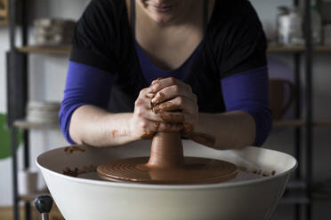 Potter forming clay on a wheel - ABZF02403