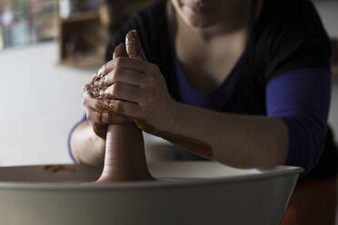 Potter forming clay on a wheel - ABZF02404