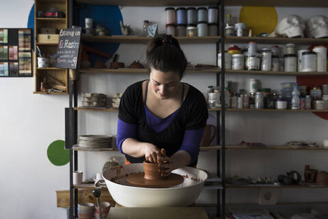 Potter forming clay on a wheel stock photo