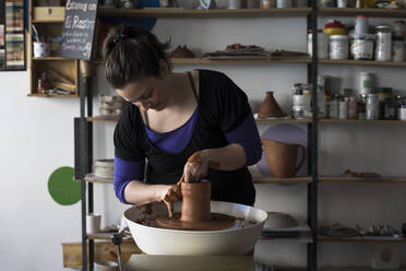 Potter forming clay on a wheel - ABZF02408