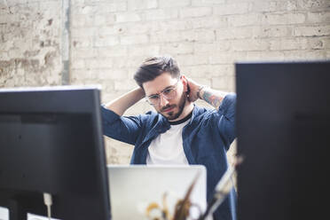 Seriöser junger Computerprogrammierer bei der Arbeit im Büro am Laptop - MASF13327