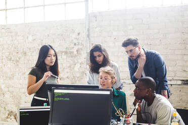 Selbstbewusste junge Berufstätige beim Planen und Programmieren am Computer am Arbeitsplatz - MASF13353