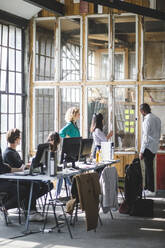 Team of young computer programmers discussing new business strategies at creative workplace - MASF13404