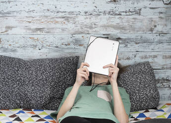 Kaukasische Frau mit digitalem Tablet auf dem Bett - BLEF09893