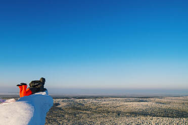 Wanderer bewundert die Aussicht von einer verschneiten Bergkuppe - BLEF09936