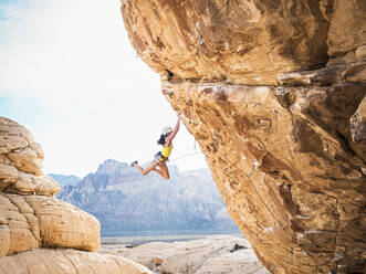 Mixed race girl rock climbing on cliff - BLEF09954