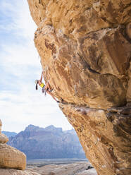 Mixed race girl rock climbing on cliff - BLEF09955