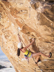 Mixed race girl rock climbing on cliff - BLEF09957