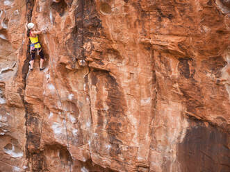 Mixed race girl rock climbing on cliff - BLEF09960