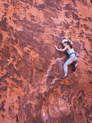 Mixed race girl rock climbing on cliff - BLEF09961
