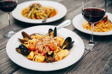 Teller mit Meeresfrüchten und Pasta mit Weingläsern - BLEF10015