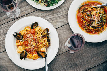 Teller mit Meeresfrüchten und Pasta mit Weingläsern - BLEF10016