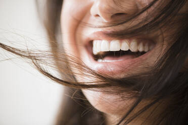 Nahaufnahme einer lachenden Frau mit unordentlichem Haar - BLEF10041