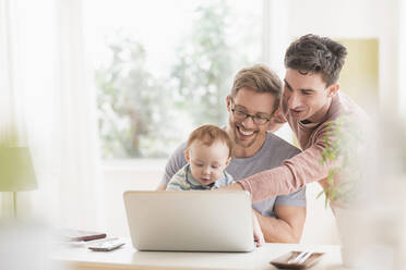 Caucasian gay fathers and baby using laptop - BLEF10073