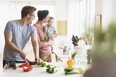 Caucasian gay fathers and baby cooking in kitchen - BLEF10076