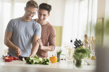 Caucasian gay couple cooking in kitchen - BLEF10078