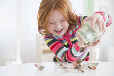 Kaukasisches Mädchen schüttet Geld aus dem Wechselgeldtopf - BLEF10101