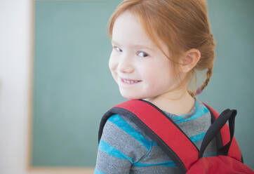 Caucasian girl wearing backpack in classroom - BLEF10103