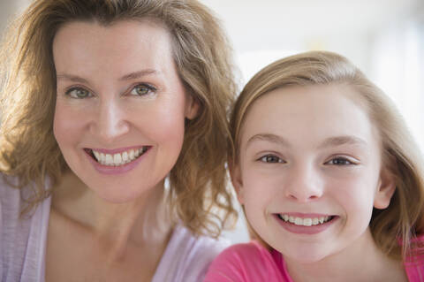 Nahaufnahme einer kaukasischen Mutter und einer lächelnden Tochter, lizenzfreies Stockfoto