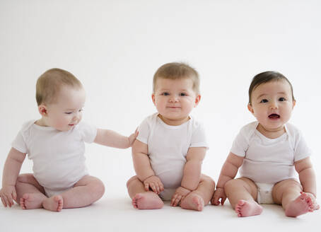 Drei Babys sitzen auf dem Boden - BLEF10116