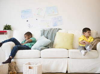 Wütende Jungen sitzen auf dem Sofa - BLEF10126