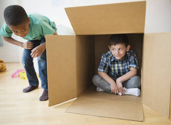 Boys playing with cardboard box - BLEF10127