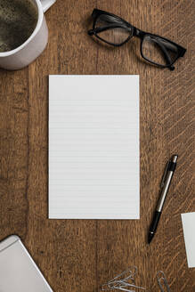 View from above blank lined notepad on wooden desk - FSIF04126