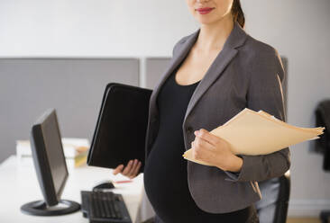 Pregnant Caucasian businesswoman working in office - BLEF10196