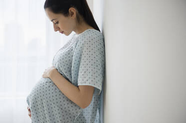 Schwangere kaukasische Frau hält ihren Bauch im Krankenhaus - BLEF10202