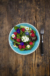 Directly above view of fresh salad in bowl by fork on wooden table - LVF08180