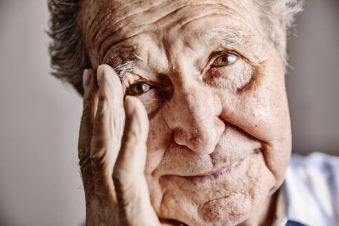 Portrait of senior man with hand on face, close-up - JATF01168
